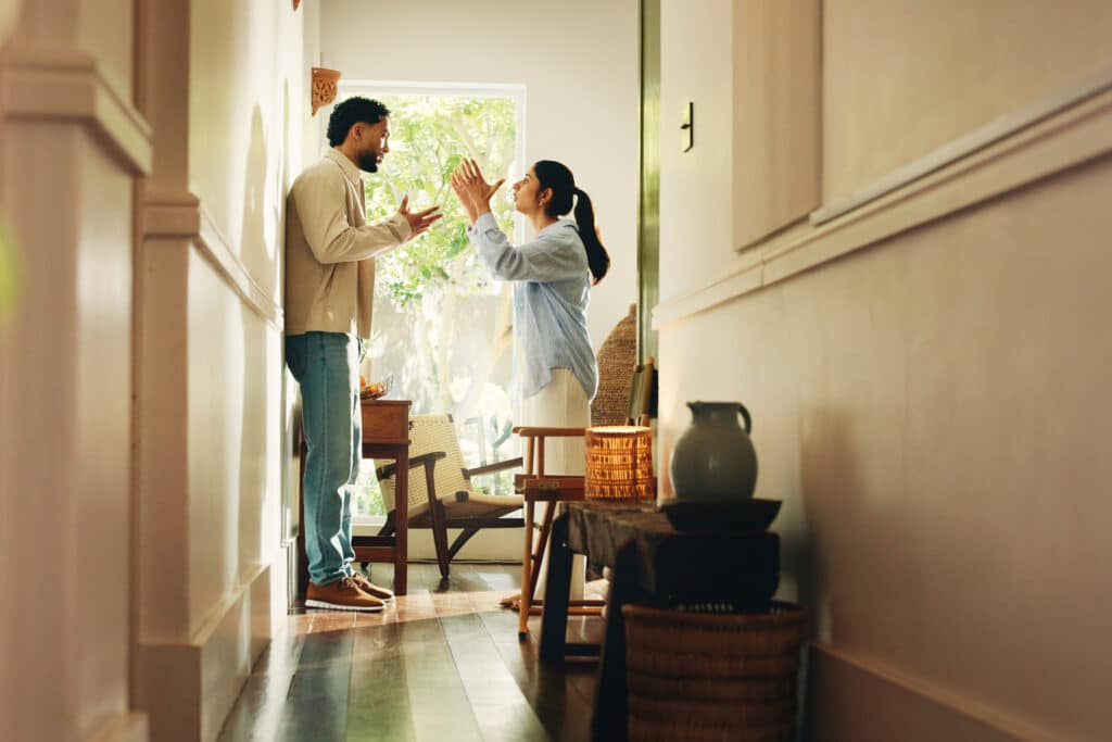 Frustrated couple, hallway or home with argument, fight or conflict for disagreement or breakup. Angry, man and woman shouting with dispute for toxic relationship, cheating affair or divorce in house.